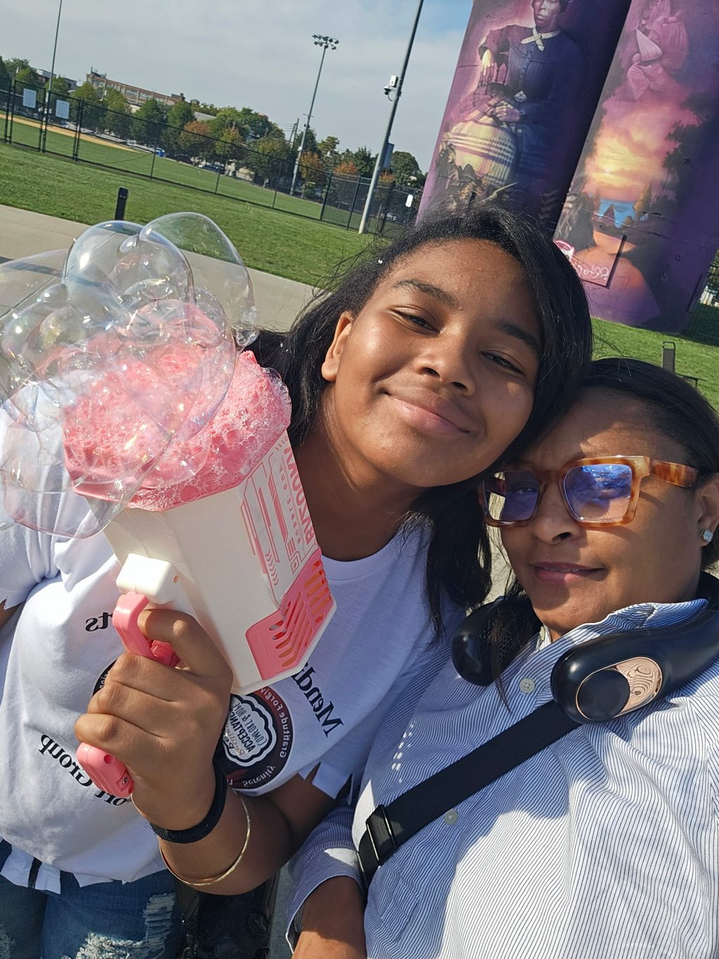 Two smiling attendees with a bubble blower at the Mending Minds & Hearts gathering